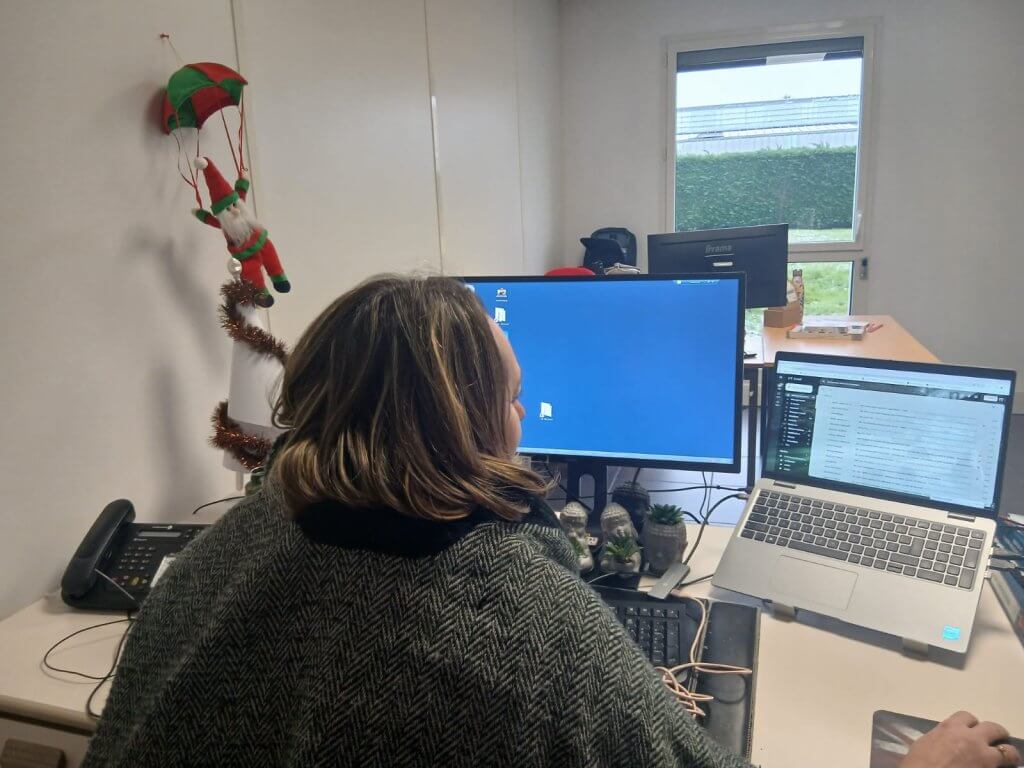 Audrey en télétravail dans un bureau, devant un PC fixe et un PC portable