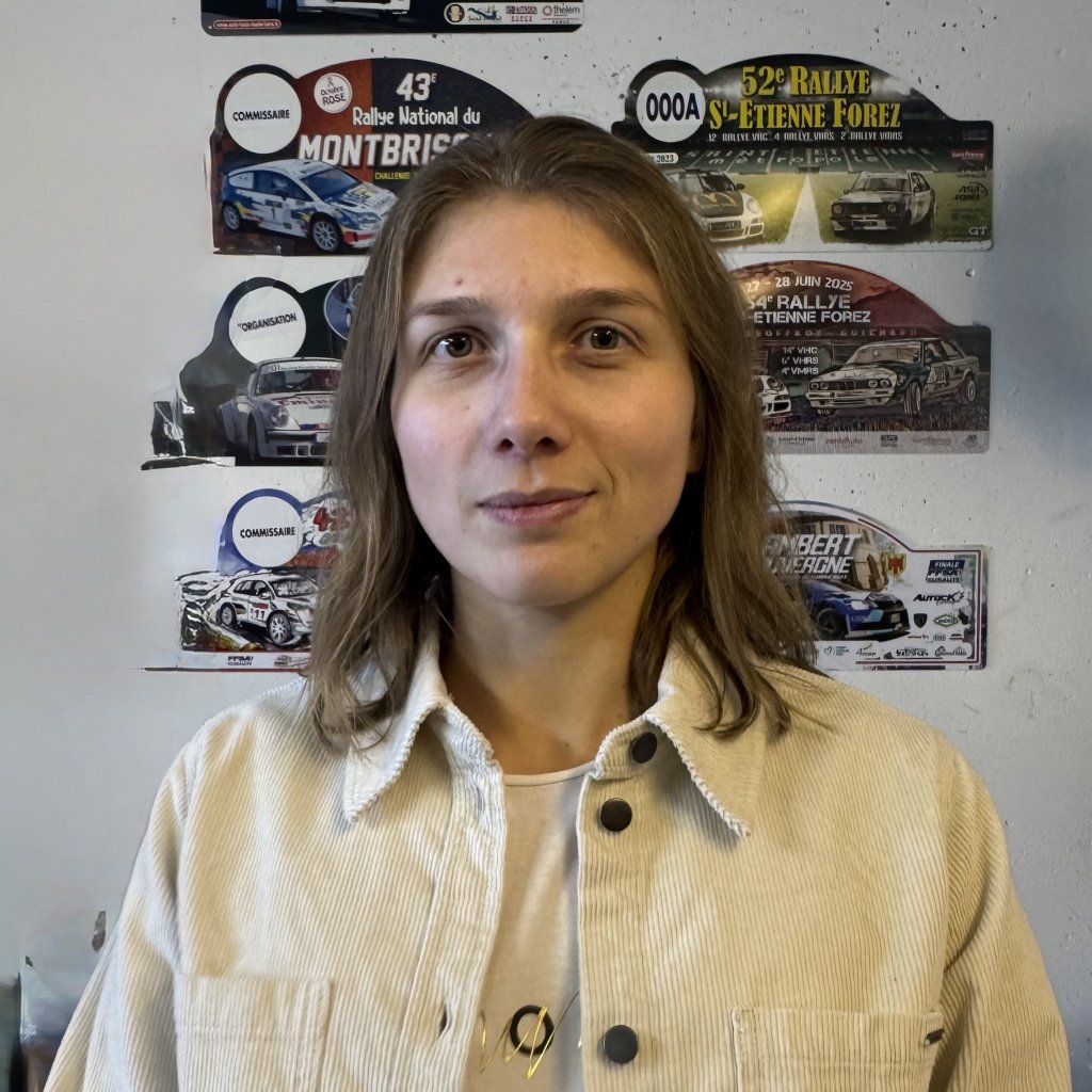 Céline Houelle-Carrot devant les plaques des rallyes auxquels elle a participé.