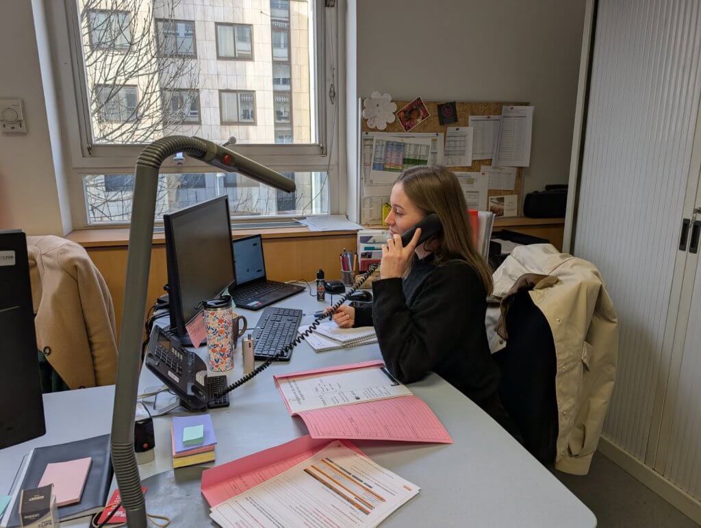 Charlotte Meilland assistante sociale au téléphone à son bureau avec des dossiers administratifs