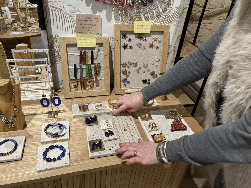 Stéphanie Petit-Jean, cheffe d'entreprise chez Pluie d'Étoiles, en train de mettre en place sa vitrine. 